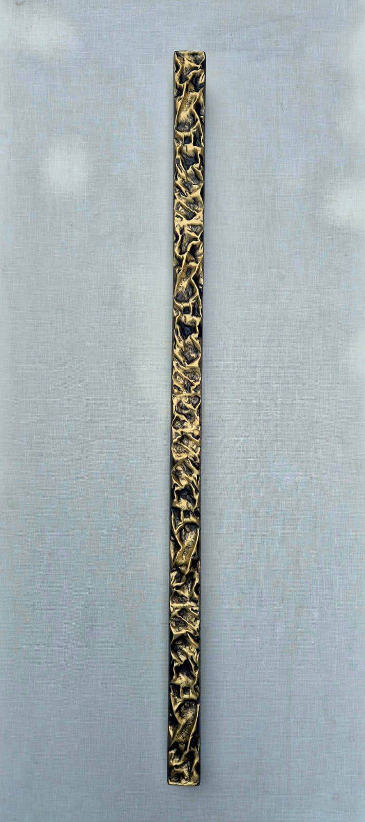 Lava pierced openwork cast brass pull bar, interlacing folded ribbons in polished gold over dark bronze, Kakal Brothers 2026 new range